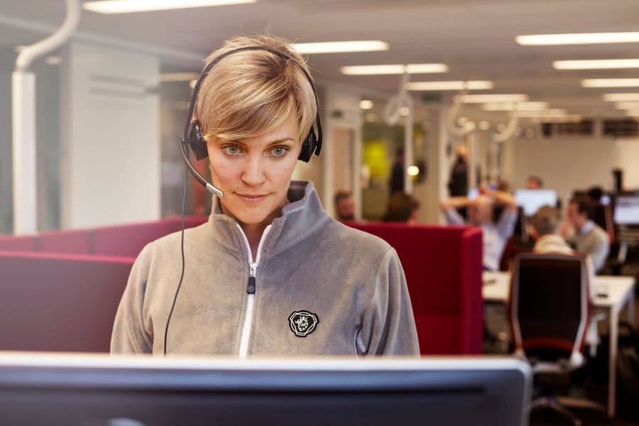 Scania-ansatt med telefon-headset som besvarer henvendelser